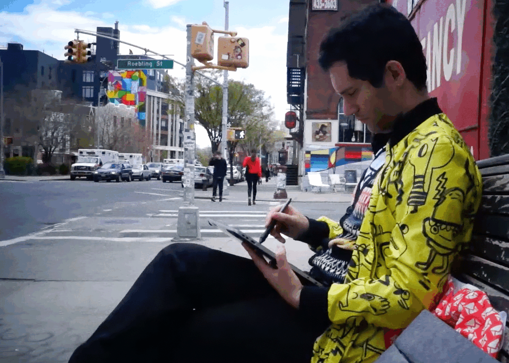Das Bild zeigt den englischen Künstler Jon Burgerman auf einer Bank sitzend in Brooklyn, New York.